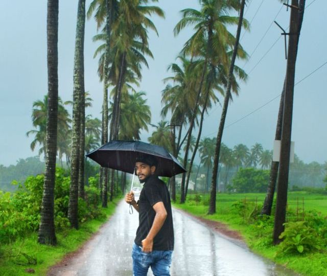 man-with-umbrella-road-amidst-trees